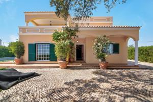 a house with potted trees in front of it at Casa do Sobreiro in Quelfes