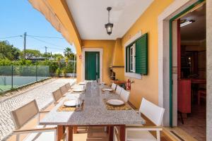 a dining room with a long table and chairs at Casa do Sobreiro in Quelfes