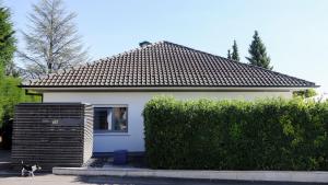 a small white house with a cat sitting in the window at Ferienwohnung Jung und Lind in Bretten