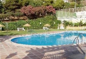 a large blue swimming pool with chairs and umbrellas at Apartment Luna in Salobreña