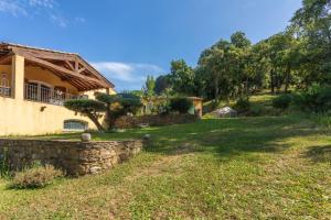 a house with a stone wall and a yard at Maison d'hôtes Collobrières in Collobrières