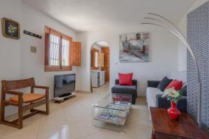 a living room with a couch and a tv at Apartment Luna in Salobreña