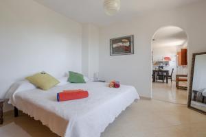 a white bedroom with a bed and a mirror at Apartment Luna in Salobreña +17 photos