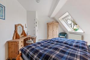 a bedroom with a bed and a desk and a mirror at Alte Bäckerei - Nis Puk in Rodenäs