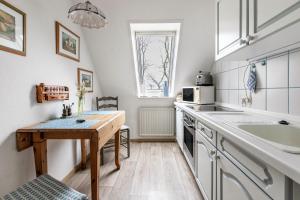 a small kitchen with a table and a sink at Alte Bäckerei - Nis Puk in Rodenäs