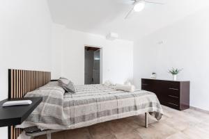 a bedroom with a large bed and a desk at Apartamento Timón in Mijas