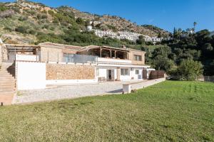 a house on the side of a hill with a yard at Apartamento Timón in Mijas