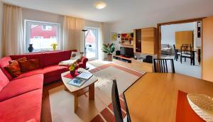 a living room with a red couch and a table at Ferienwohnung Tannenblick 3-2 in Oberhof