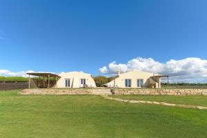 two white houses in a field with a blue sky at Paraiso da Serva - Flor do Rosto 2 in Odemira