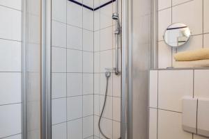 a shower in a bathroom with white tiles at Ferienwohnung Tannenblick 3-2 in Oberhof