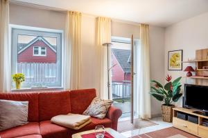 a living room with a couch and a large window at Ferienwohnung Tannenblick 3-2 in Oberhof