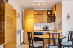 a kitchen with wooden cabinets and a table and chairs at Ferienwohnung Tannenblick 3-2 in Oberhof +17 photos