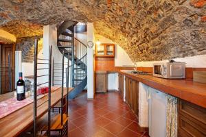 a kitchen with a staircase in a stone wall at Cascina Taronico in Bellagio
