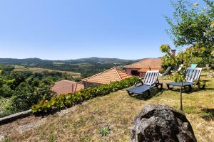 two chairs sitting on top of a hill at Casas do Natureza de Coura in Paredes de Coura