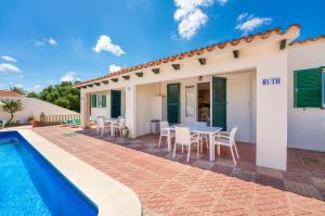 a villa with a swimming pool and a table and chairs at Villas Vanessa & Ruth in Cala en Porter