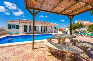 a villa with a swimming pool and a patio at Villas Vanessa & Ruth in Cala en Porter