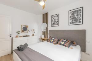 a bedroom with a white bed and a mirror at Casa con terraza cerca del mar in Telde