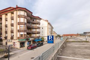 a parking lot with a parking sign in front of a building at Estudio La Barquera in San Vicente de la Barquera