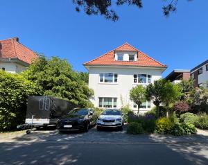 two cars parked in a parking lot in front of a house at Ferienwohnung am Olantis in Oldenburg