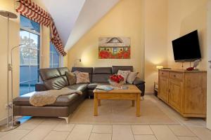 a living room with a couch and a tv at Wellness-Residenz Wohnung 19 in Zingst