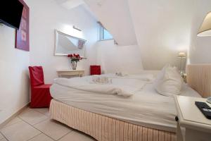 a large white bed in a room with a red chair at Wellness-Residenz Wohnung 19 in Zingst