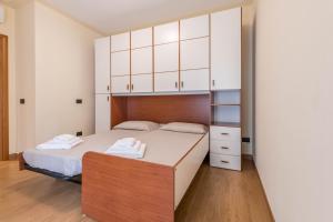 a bedroom with a bed and white cabinets at Passioncasa in Torri del Benaco +22 photos