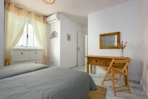 a bedroom with a desk and a bed and a mirror at Casa Patagonia in Manilva +21 photos