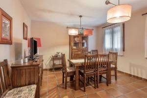 a dining room with a table and chairs and a television at Cuatro Torres in Campillo