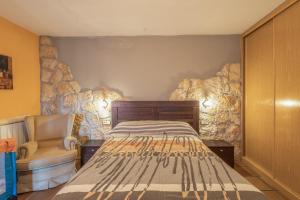 a bedroom with a bed and a chair at Cuatro Torres in Campillo