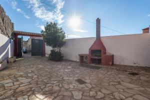 a building with a brick courtyard with a fireplace at Cuatro Torres in Campillo