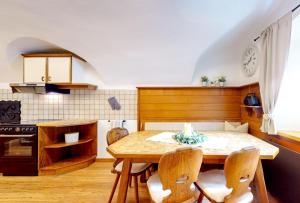 a kitchen with a table and chairs in a room at Apart Hennewinkl in Oetz