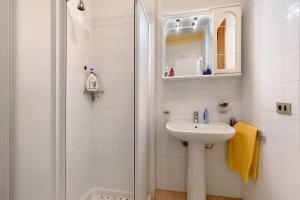 a white bathroom with a sink and a shower at Brezza del lago in Desenzano del Garda +17 photos