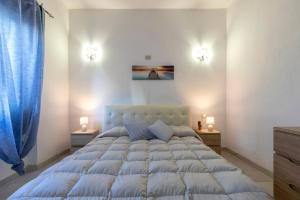 a bedroom with a large bed with two lights on it at Villetta I Pitosfori in Palmadula