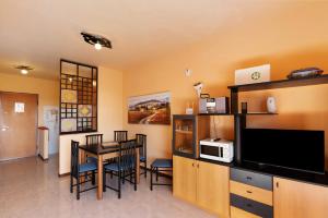 a kitchen and dining room with a table and a tv at Brezza del lago in Desenzano del Garda