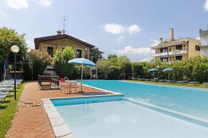 a swimming pool with umbrellas next to a building at Brezza del lago in Desenzano del Garda