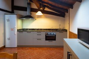 a kitchen with white cabinets and a white refrigerator at Pagorriaga in Beasain