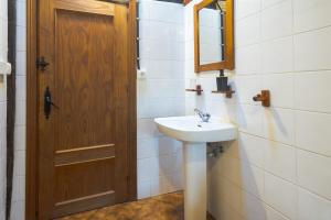 a bathroom with a sink and a wooden door at Pagorriaga in Beasain