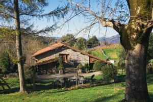 a log cabin in a field with a tree at Pagorriaga in Beasain