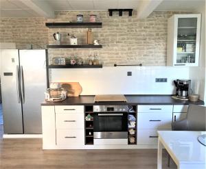 a kitchen with a stainless steel refrigerator and white cabinets at Haus Sonnenschein in Janneby
