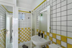 a bathroom with yellow and white tiled walls and a sink at Los Adejo vacacional in Moya +31 photos