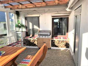 a screened in porch with a grill and tables at Haus Sonnenschein in Janneby +4 photos
