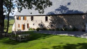 a stone barn with a picnic table in front of it at La Trouverie in Laqueuille