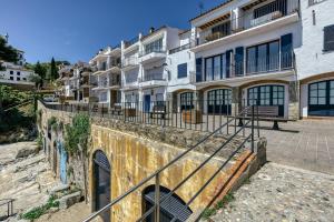 a row of apartment buildings on a stone wall at Loft Calella de Palafrugell in Calella de Palafrugell