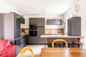 a kitchen with stainless steel appliances and a wooden table at Ker Pathabac in Préfailles