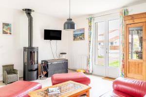 a living room with red furniture and a fireplace at Ker Pathabac in Préfailles