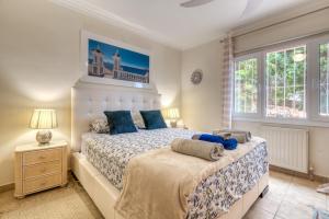 a bedroom with a large bed with blue pillows at Villa Shalimar Moraira in Teulada +25 photos