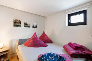 a bedroom with a bed with red pillows and a window at Loft Sven in Baden-Baden