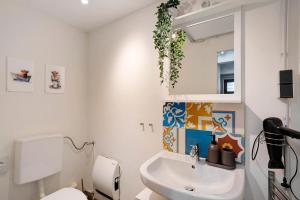 a bathroom with a sink and a toilet and a mirror at Loft Sven in Baden-Baden +20 photos