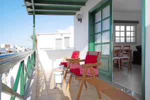 a balcony with chairs and a table on a building at Los Alisios del Patron in Playa Honda