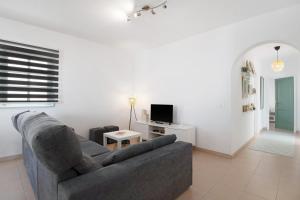 a living room with a couch and a tv at Los Alisios del Patron in Playa Honda